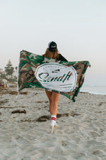 Person holding a branded flag on a beach