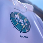 Close-up of a product with an embroidered logo and text on a light blue background